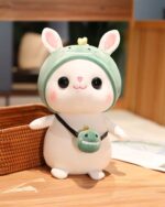 Cute kawaii bunny plushie, Cotton, wearing a green hat and carrying a small charm.