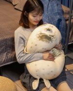 Kawaii chonky sea lion plushie being held by a person, soft and cuddly.