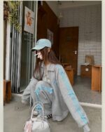 Woman wearing a grey korean aesthetic set with blue ribbon details, paired with a blue baseball cap.