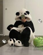 Person wearing thick, fluffy panda pajamas with a hood and paws. Kawaii aesthetic panda pajamas.