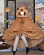 A brown capybara cloak, featuring a hood and drawstring details, worn by a person.