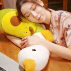 Close-up of a yellow banana duck plushie resting on a wooden table.