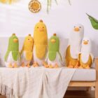 A set of colorful banana duck plushies arranged on a sofa with a blanket.