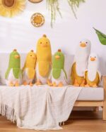 A set of colorful banana duck plushies arranged on a sofa with a blanket.
