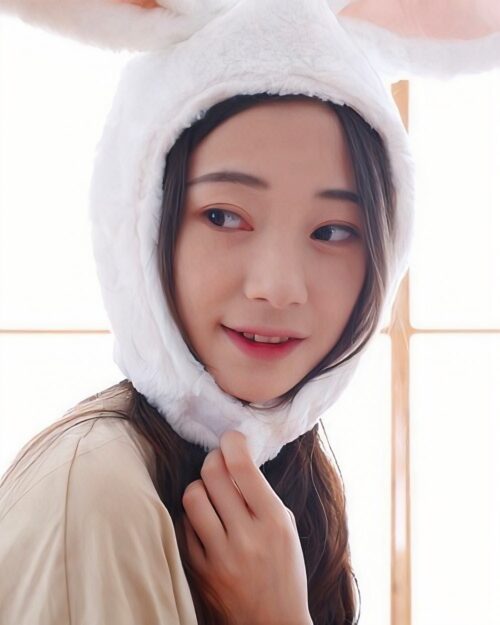 A woman wearing a white kawaii bunny ears hat.