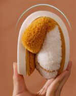 Close-up of cat paw slippers, featuring a fluffy, golden exterior and a white, plush interior.