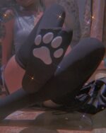 Close-up of black cat paw socks on a leg, showcasing the design.