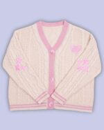 Pale pink cable-knit kawaii embroidered sweater with star and heart appliques.