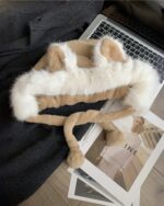 Fox ears hat displayed on a magazine and beside a laptop.
