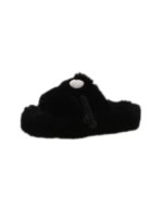 Black fluffy hand holding slippers isolated on white background.