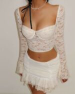 White lace coquette aesthetic set featuring a long-sleeved crop top and ruffled mini skirt.