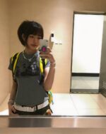 Woman wearing a retro grunge t-shirt, layered with a graphic tee and accessories.