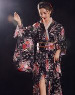 Black satin japanese kimono with floral embroidery, featuring wide sleeves and a belted waist.