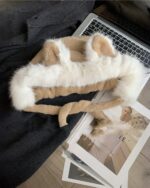 Fox ears hat plush, soft fur headwear displayed on a table with a laptop and magazine.