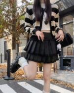 Black and white pleated korean aesthetic skirt worn by a model outdoors.