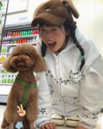 Person wearing a y2k kaomoji hoodie with a dog. Fun, Y2K aesthetic sweatshirt.