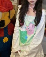 Kawaii lime shirt featuring a pastel strawberry design and star accents.