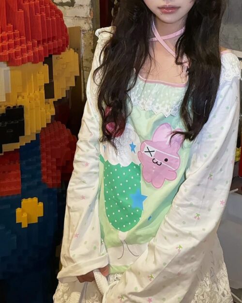 Kawaii lime shirt featuring a pastel strawberry design and star accents.