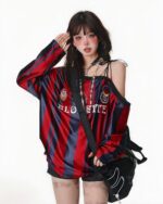 Off shoulder sport sweatshirt featuring a coquette aesthetic, red and blue striped design, and decorative crests.