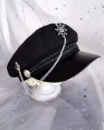 Close-up of a gothic style army hat with chain and decorative pin details.