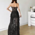 Back view of a black gothic aesthetic dress with lace detailing and a flowing skirt.