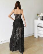 Back view of a black gothic aesthetic dress with lace detailing and a flowing skirt.
