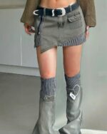 Grey y2k aesthetic skirt with pockets and zipper details, paired with striped socks and boots.