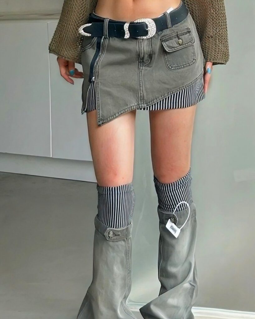 Grey y2k aesthetic skirt with pockets and zipper details, paired with striped socks and boots.