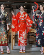 Three women wearing satin-fabric japanese floral kimono robes in different colors and patterns.