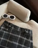 Plaid mini skirt in preppy aesthetic style, featuring sunglasses.