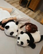 Two kawaii panda plushies lying on a bed, soft and cuddly.