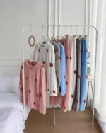 Colorful korean aesthetic pajamas suit on a rack, featuring strawberry bear print design.