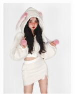 Woman wearing bunny hooded plush pajamas, soft white fleece, kawaii style sleepwear.