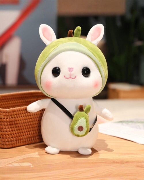 Kawaii bunny plushie, Cotton the Adventurous Rabbit toy. Soft, white plush with a green hat and avocado accessory.