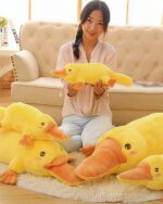 Two yellow kawaii platypus plushies displayed with a person.