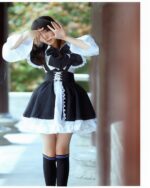 A young woman wearing a black and white classic maid outfit, complete with lace and stockings.