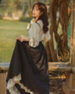 Black cottagecore dress with lace trim, featuring a flowing skirt and matching blouse. French style fashion.