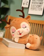 Cute baby deer plushie resting on a book. Soft, cuddly toy.