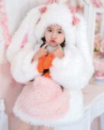 Child wearing an Easter bunny costume, featuring a fluffy hat and pink dress. It’s a parent and child easter bunny costume.