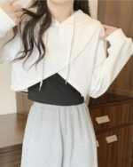 Irregular hooded top - Korean aesthetic hoodie, featuring a white crop top with a black lining and gray trousers.