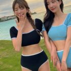Two women wearing a high-waisted two-piece korean aesthetic swimsuit on a grassy area.