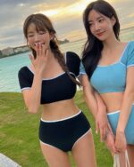 Two women wearing a high-waisted two-piece korean aesthetic swimsuit on a grassy area.