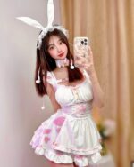 A woman wearing a bunny girl maid costume, featuring pink and white frills, ears, and a bib.