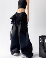 Black y2k cargo pants with a ruffled skirt and lace detailing. Unique fashion style.