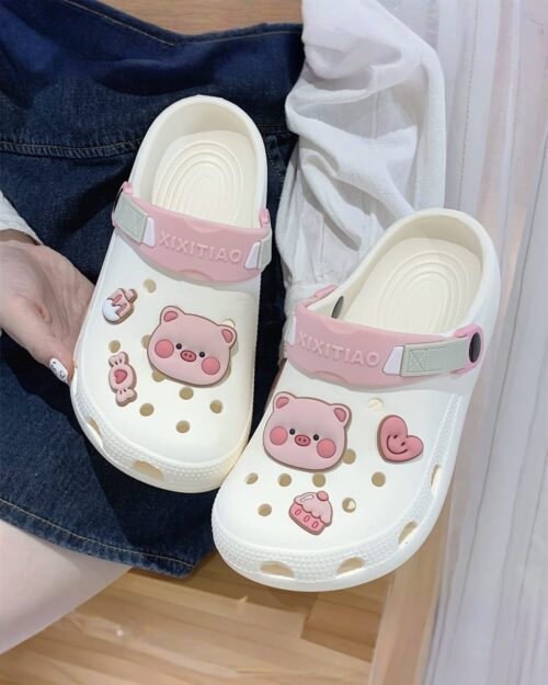 White Piggy Crocs with pink accents and character designs.