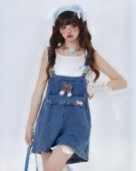 Blue kawaii denim overalls worn by a model with a headband and accessories.
