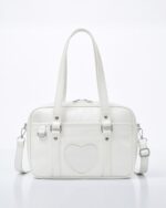 White japanese schoolbag with heart detail, top handle and shoulder strap.