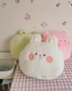 Assorted kawaii animal plushie cushions including a white bunny, pink bear, and green sheep.
