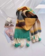 Close-up of a fluffy, rainbow-colored scarf with pom-poms. A kawaii rainbow scarf.