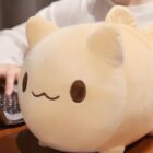 Close-up of a beige round neko plushie with brown eyes and ears.